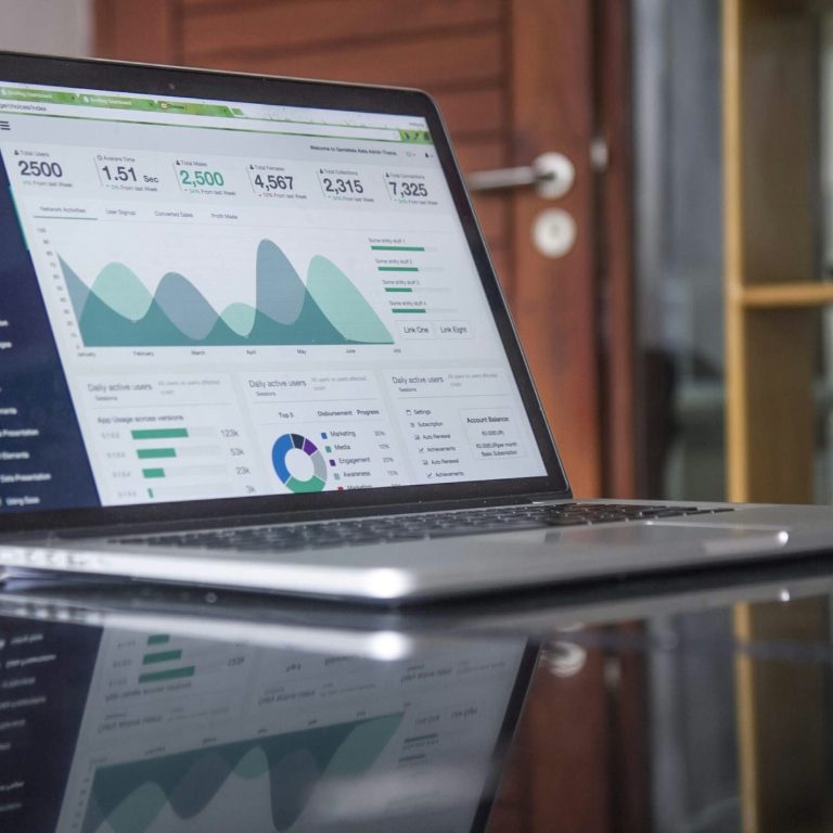 Laptop mit Dashboard für Datenanalysen auf einem Tisch.