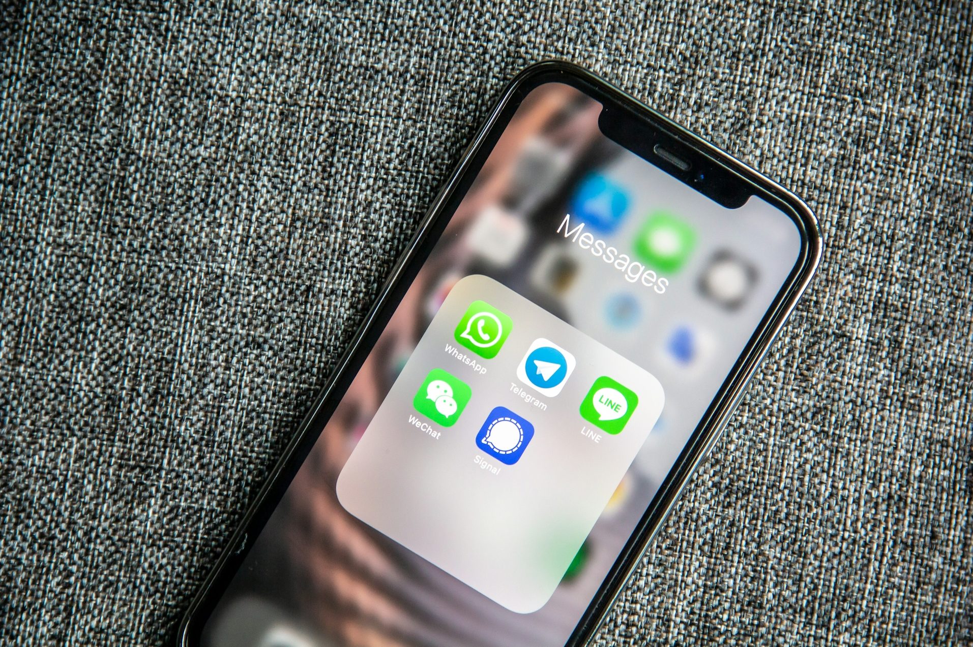 Smartphone-Bildschirm mit Messaging-App-Icons auf einem grauen Hintergrund.